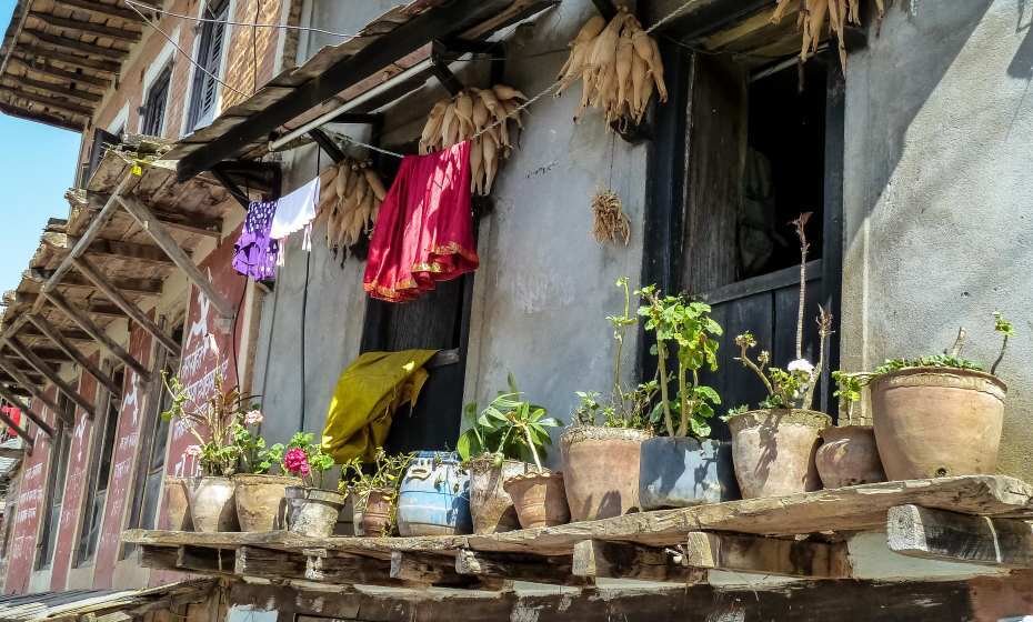 ypical Nepalese building with balcony decorated with flowerpots and cloth ropes, Bandipur, Nepal