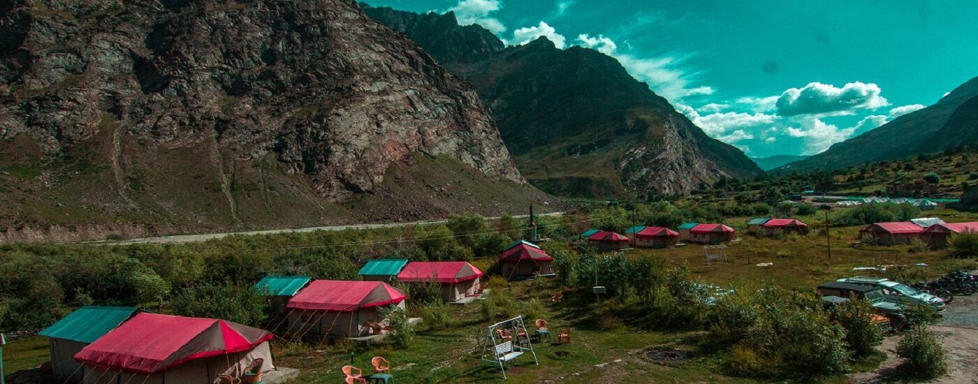 View of the tents at Padma Lodge Jispa with a backdrop of blue sty and mountains