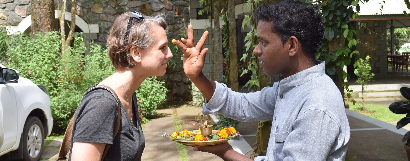 World Tourism Day 2024 - A customer being greeted at a hotel - the staff member dabbing her forehead with a traditional powder dot