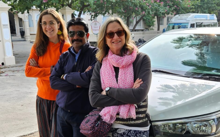 Photo of Jocelyn and travel companion with driver all crossing arms and smiling in front of a silver car