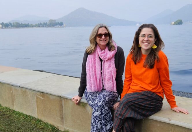 Photo of Jocelyn and other travelling companion in front of misty mountains and a large lake