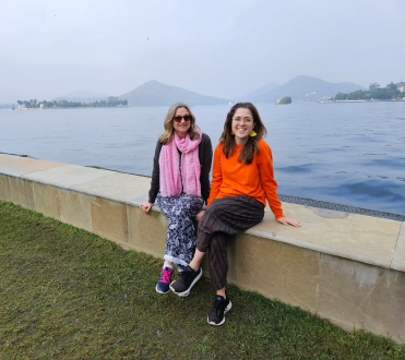 Photo of Jocelyn and other travelling companion in front of misty mountains and a large lake